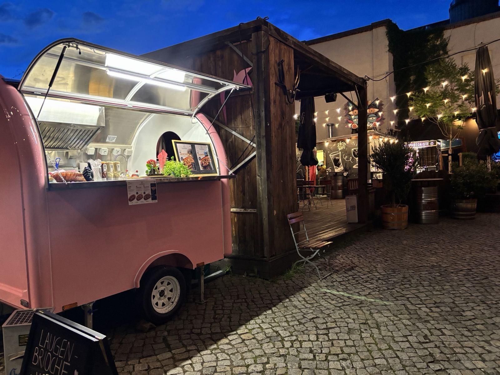 Der pinke Foodtruck 21 EINUNDZWANZIG abends mit beleuchteter Ausgabe